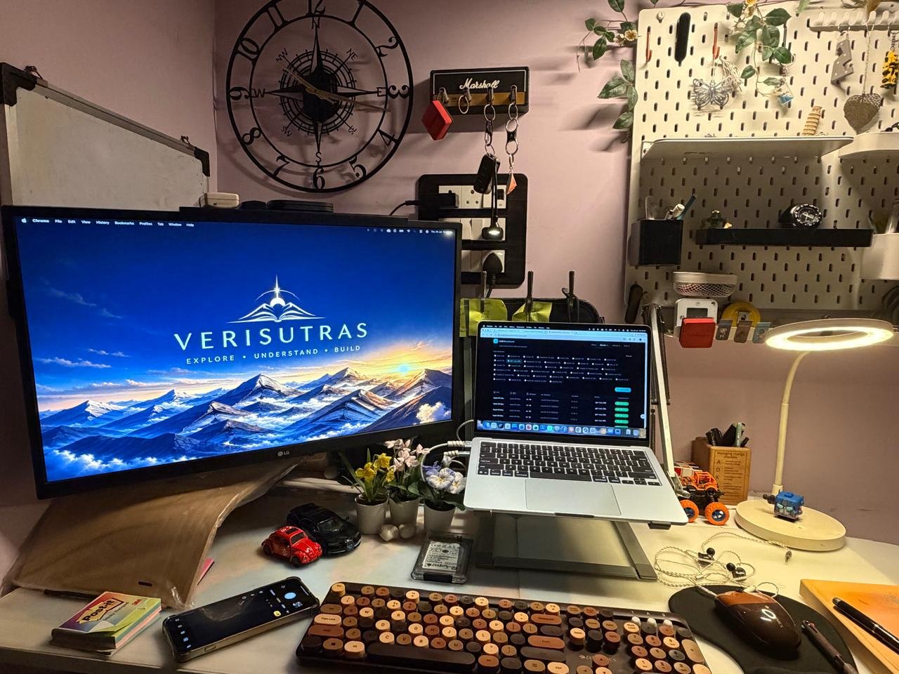 A thin silver laptop with a dark technical workspace on screen, on a desk in a calm office.
